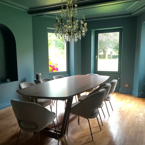 Salle à manger aux murs bleu-vert avec grande table en bois