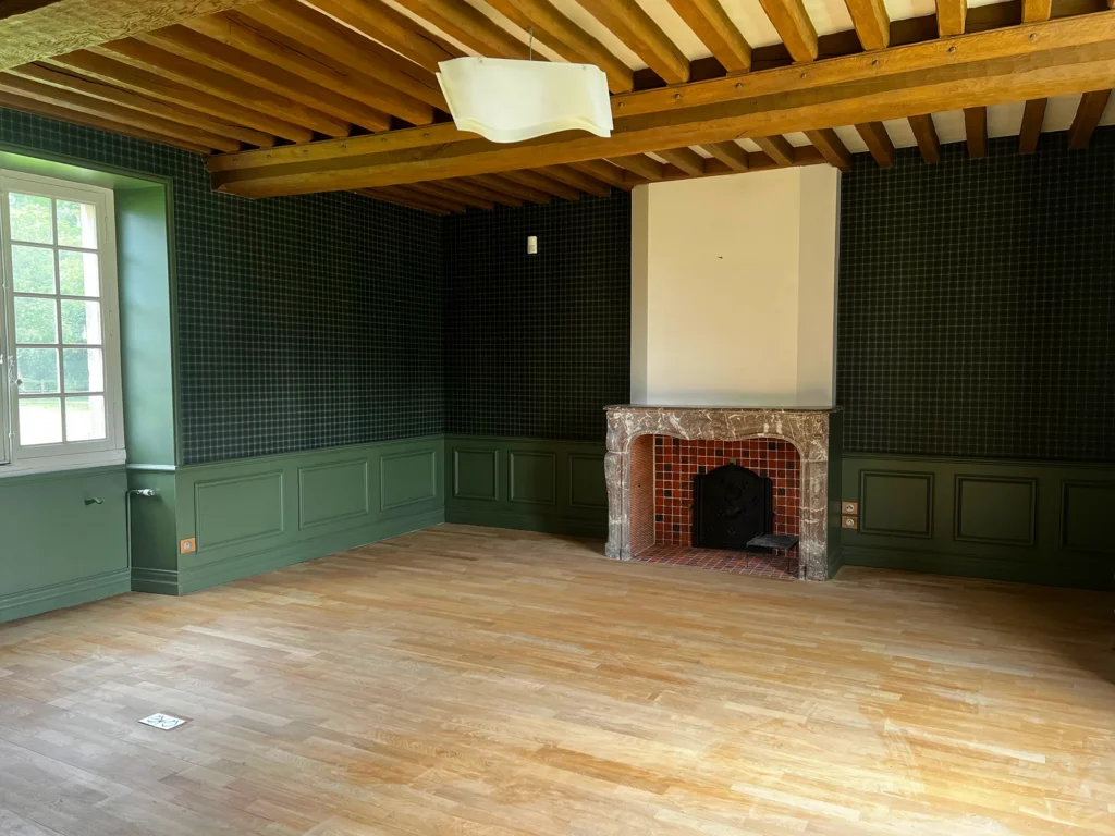 Salle d'un château en Normandie après peinture, soubassement vert et poutres apparentes