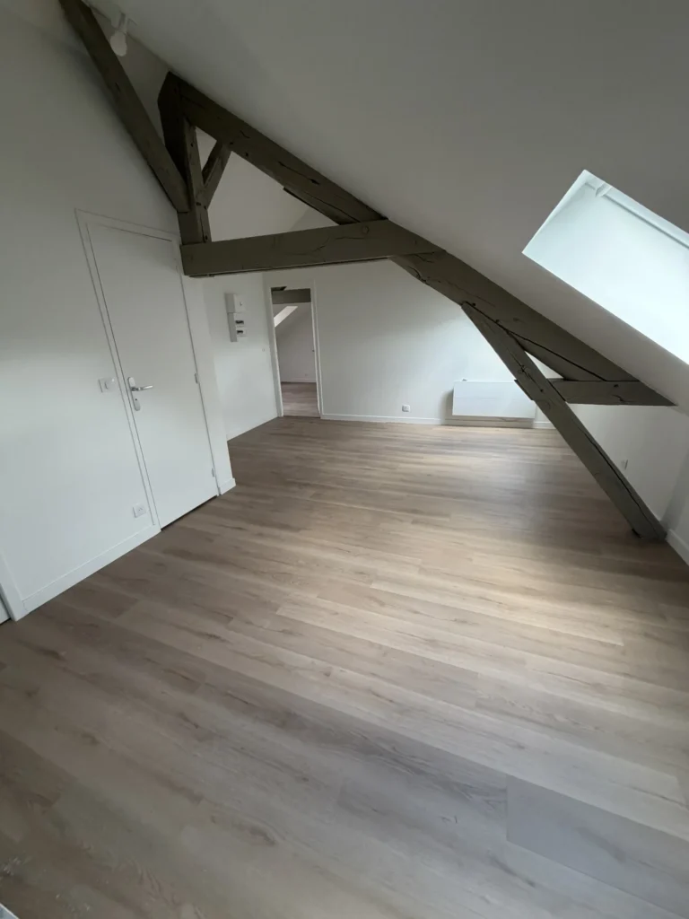 Poutres poncées et sol stratifié posés lors de la rénovation complète